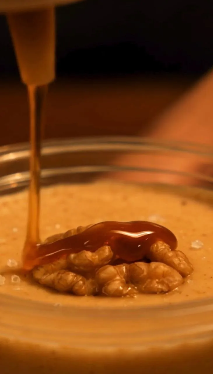 Caramel drizzling onto a walnut atop the Cream Kiss